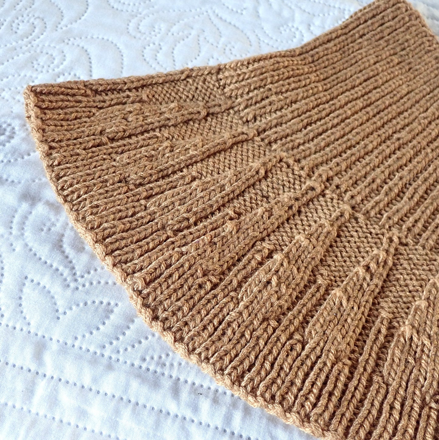 Murretun oranssinkeltainen neulottu kauluri, jonka muoto ja ulkonäkö muistuttavat kantarellia.