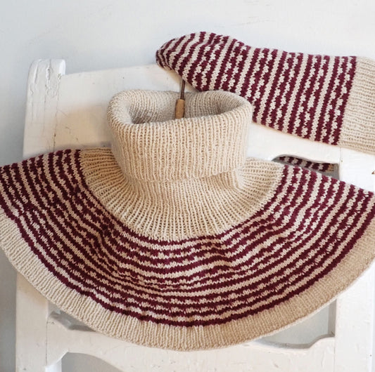 Vanhan, valkoisen puutuolin selkänojalle on ripustettu kaarrokekauluri ja pipo. Neuleissa on beiget ja tummanpunaiset raidat, joissa koristeena mosaiikkineulekuvioita. Kuviot muistuttavat hammastusta.