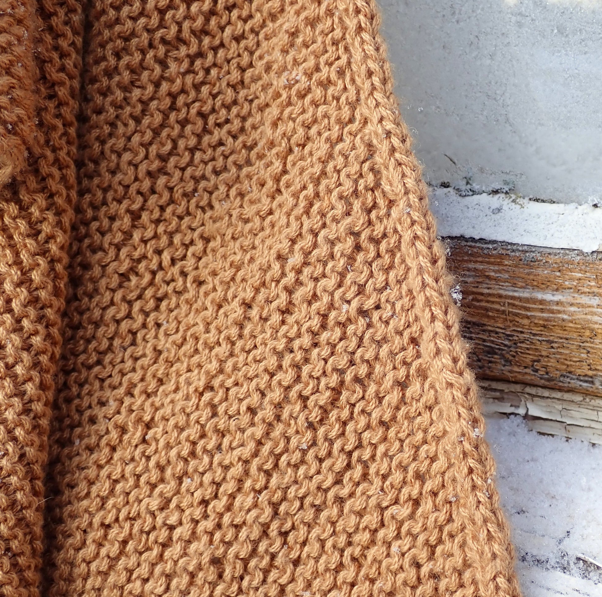 Viljankeltaisen kolmiohuivin pintaa ja nyörireunusta.