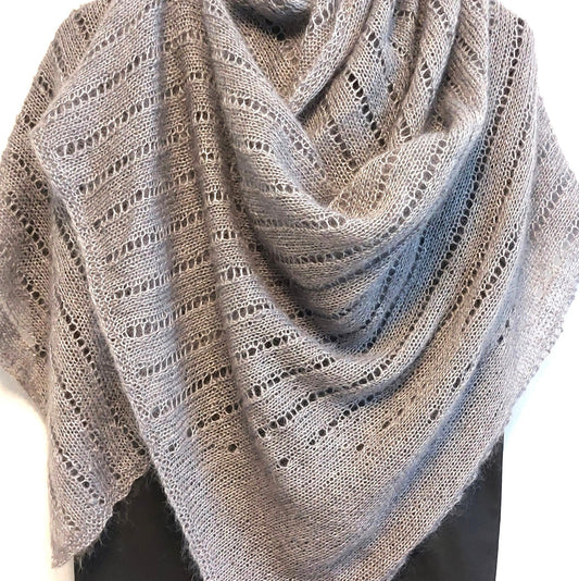 Harmaa pitsineulehuivi on laskostettu hartioille. Huivissa on reikäneuleraitoja.