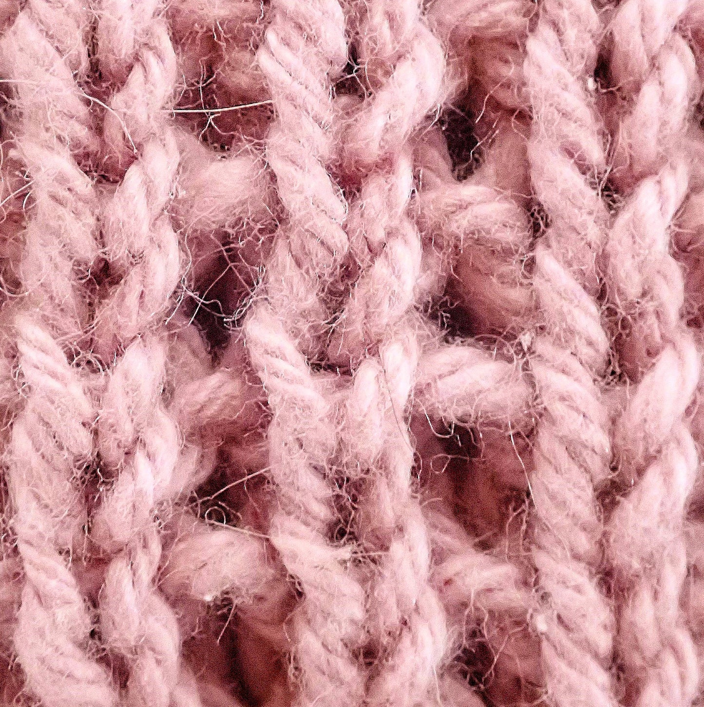 Vaaleanpunaista pintaneuletta, jossa silmukat muodostavat pystysuoria raitoja.