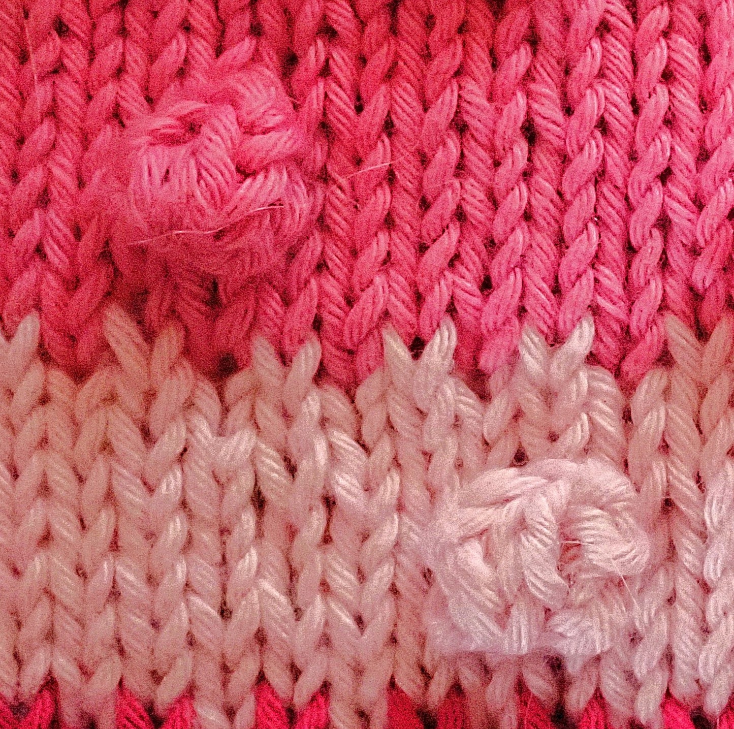 Neulepintaa, jossa on alhaalla vaaleanpunainen raita ja ylhäällä pinkki raita. Molemmissa on nyppyjä. Raitojen rajalla on nostettu joka toinen silmukka neulomatta.