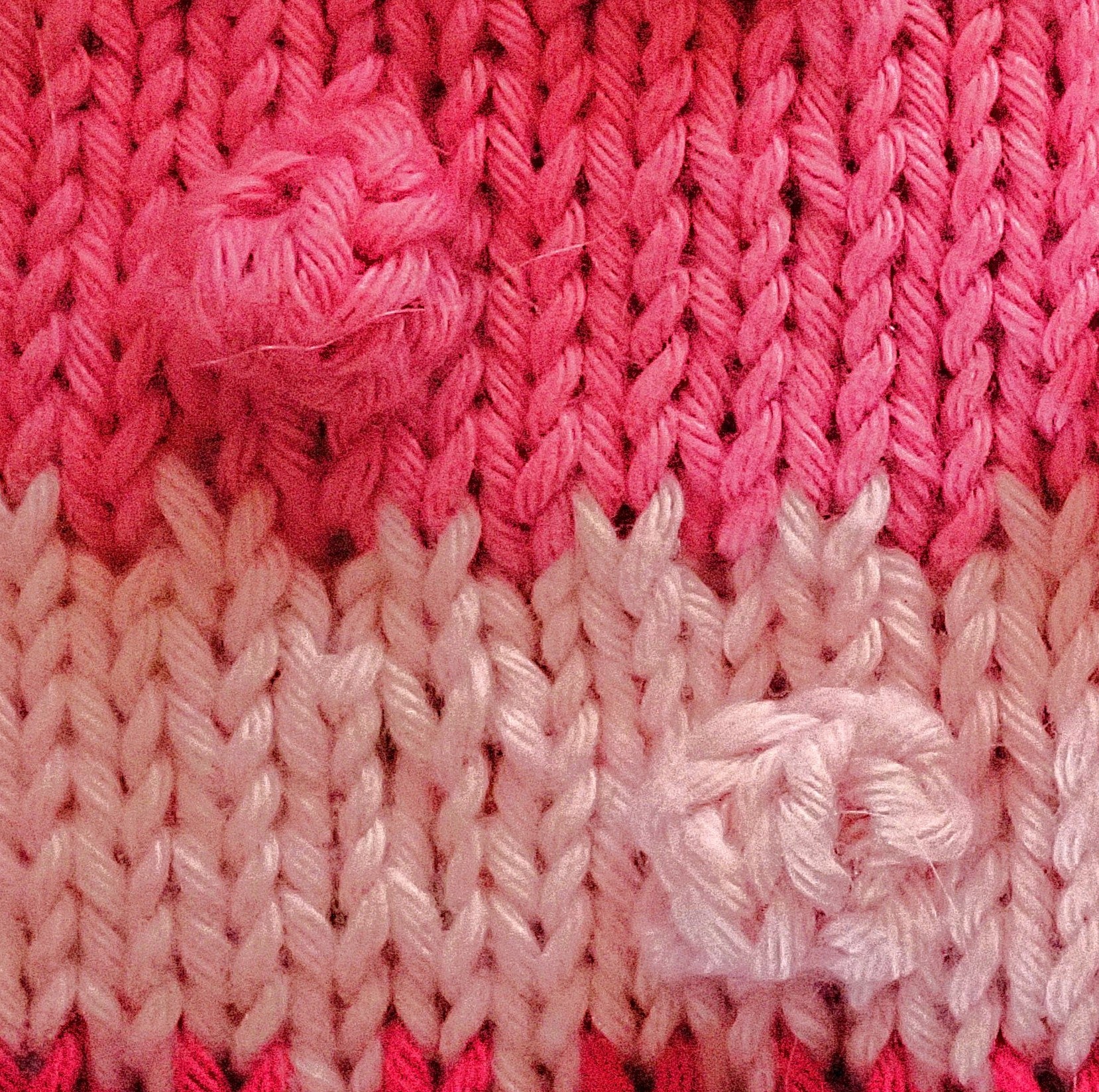 Neulepintaa, jossa on alhaalla vaaleanpunainen raita ja ylhäällä pinkki raita. Molemmissa on nyppyjä. Raitojen rajalla on nostettu joka toinen silmukka neulomatta.